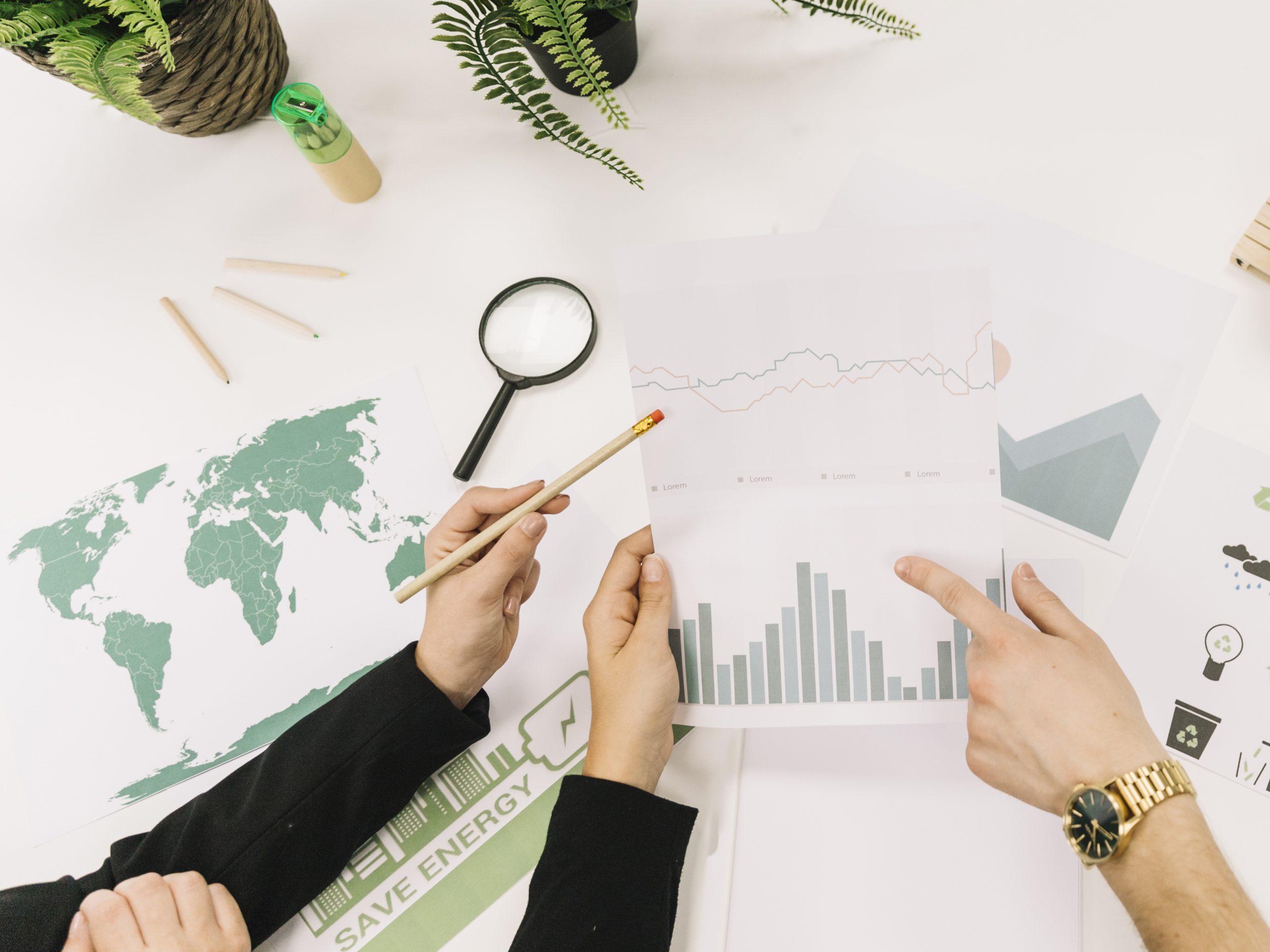 elevated-view-of-businesspeople-analyzing-graph-over-desk